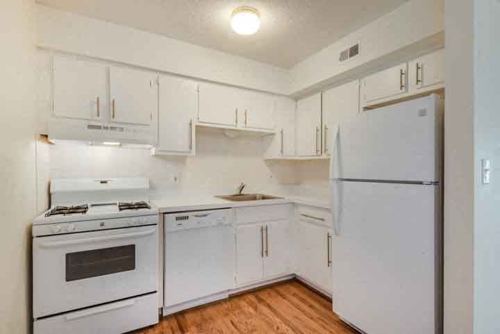 a white kitchen with white appliances and white cabinets