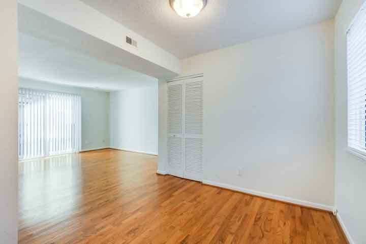 an empty living room with white walls and wood floors