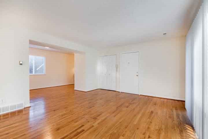 an empty living room with white walls and wood floors