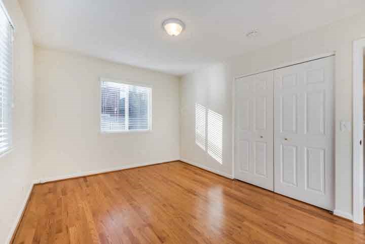 an empty living room with white walls and wood floors