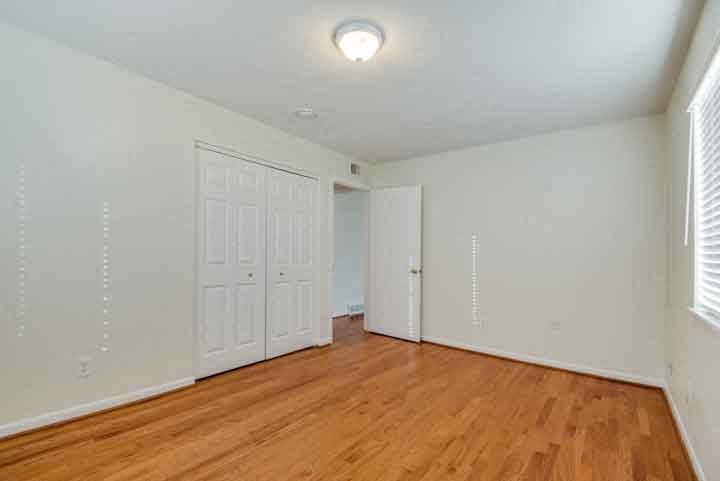 an empty living room with white walls and wood floors
