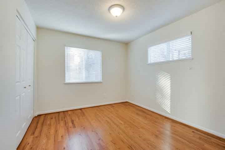an empty room with a wooden floor and white walls
