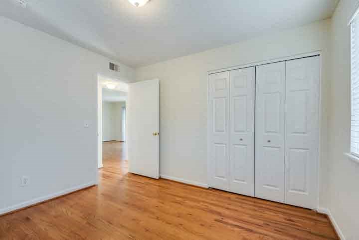 an empty living room with white walls and wood floors