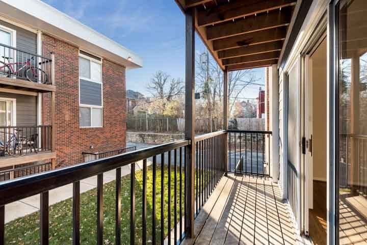 a balcony with a view of a yard and a building