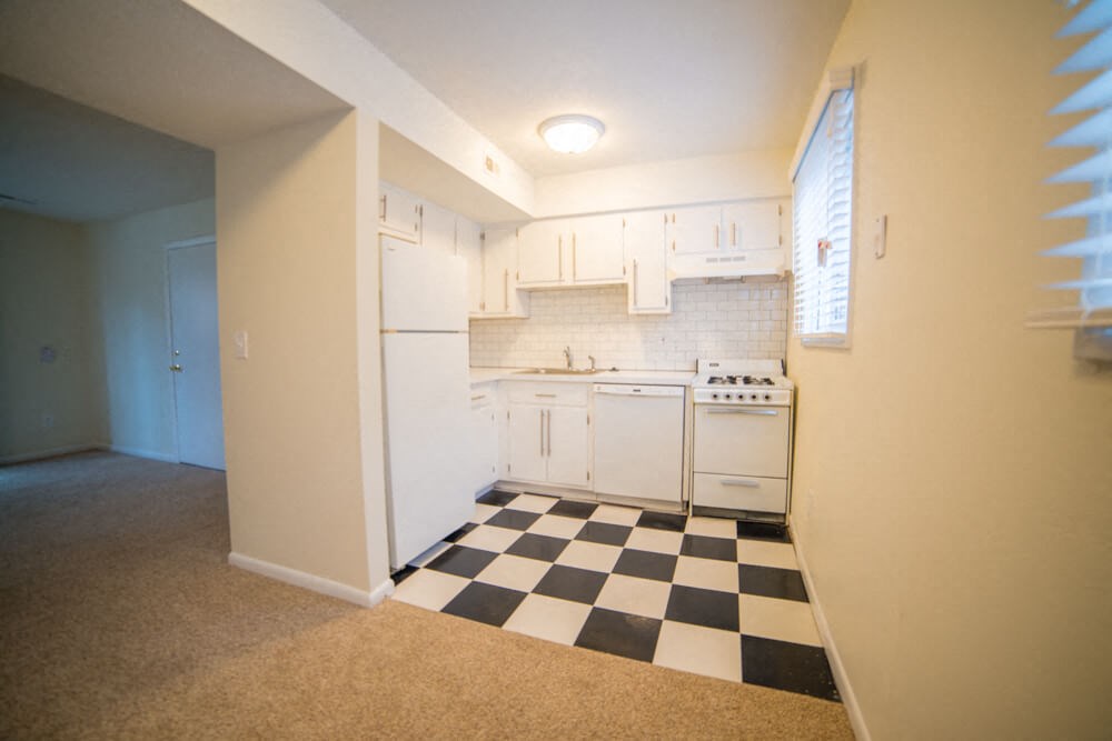 a kitchen with a checkered floor and white appliances