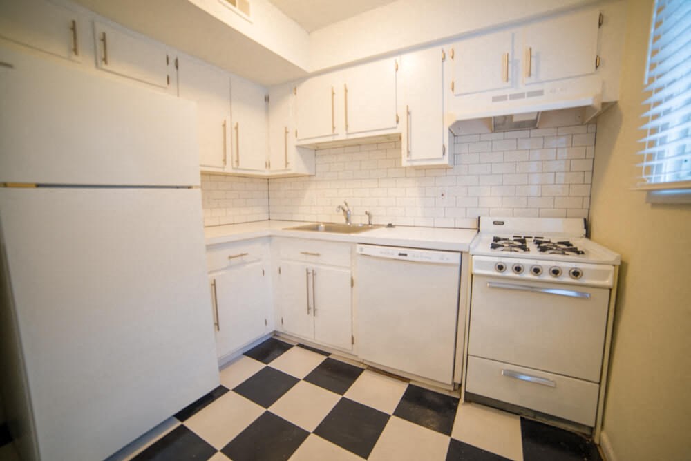 a kitchen with a checkered floor and white appliances