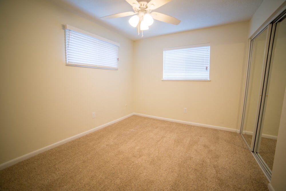 a bedroom with a ceiling fan and a closet