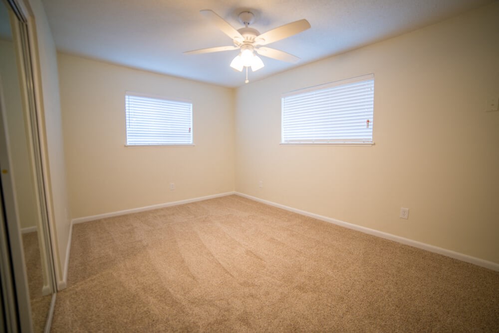 a room with carpet and a ceiling fan