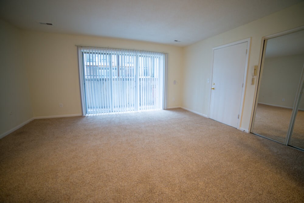 an empty living room with a sliding glass door