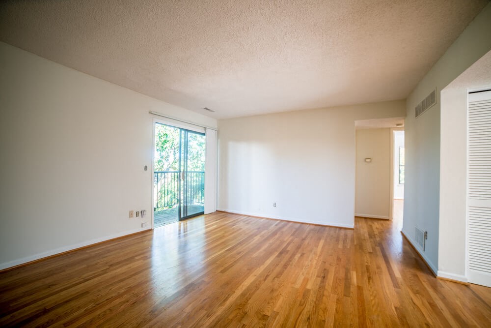the living room and dining room of an empty house with wood floors