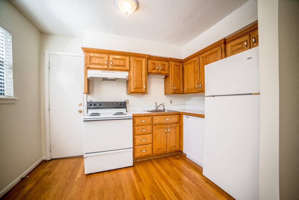 a kitchen with white appliances and wooden cabinets