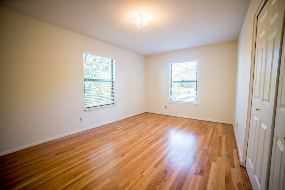 a living room with wood floors and white walls