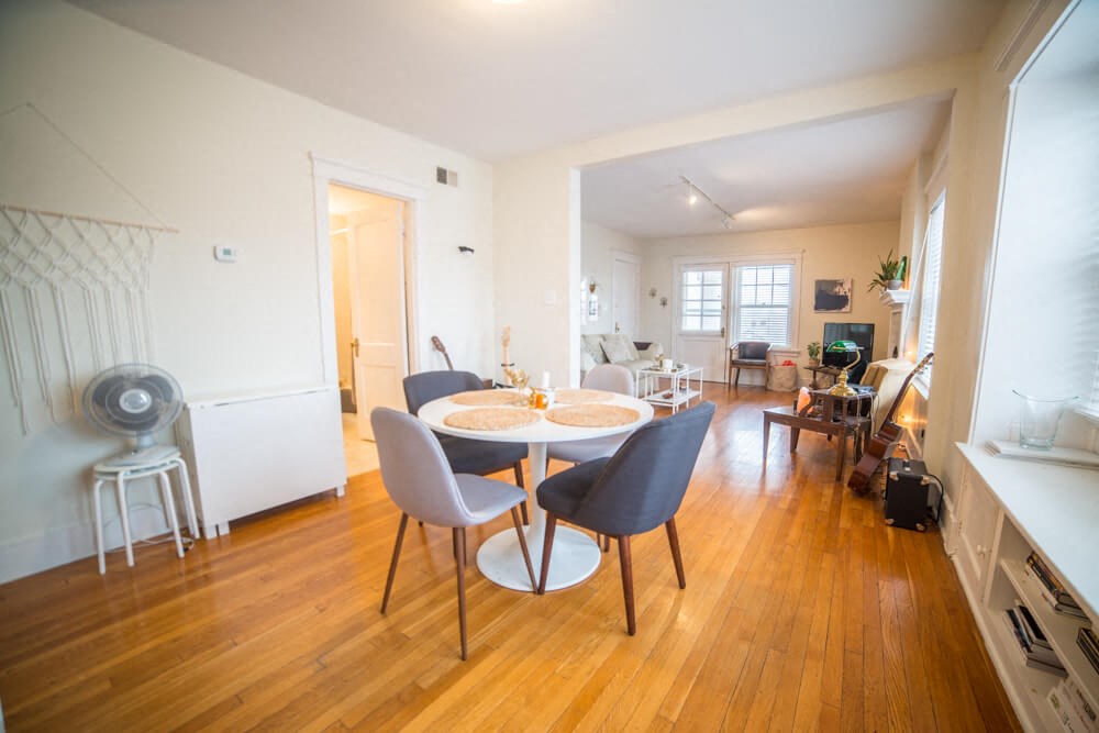 a living room and dining room with a table and chairs