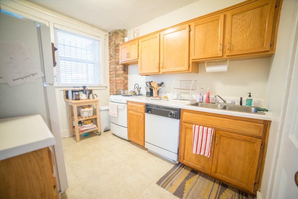 a kitchen with white appliances and wooden cabinets
