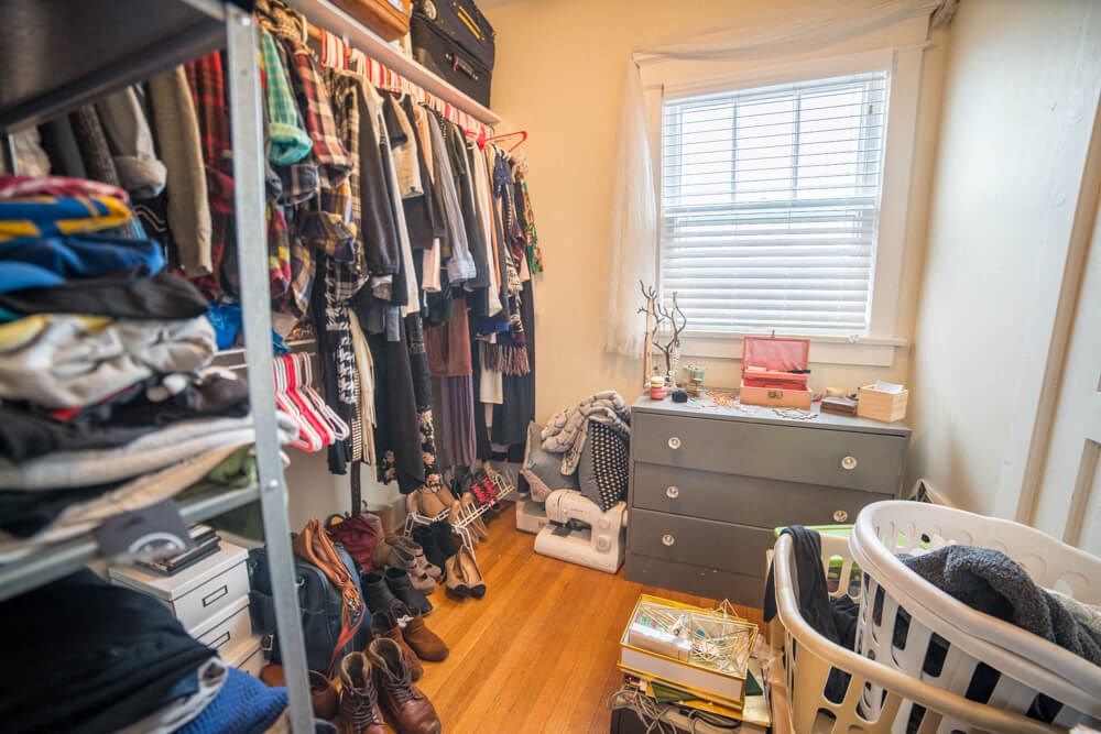 a closet filled with clothes and a dresser in a room