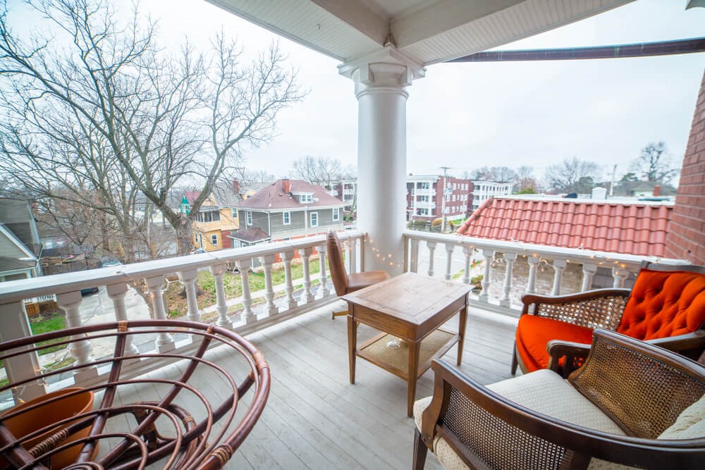 a balcony with a table and chairs and a view of a town