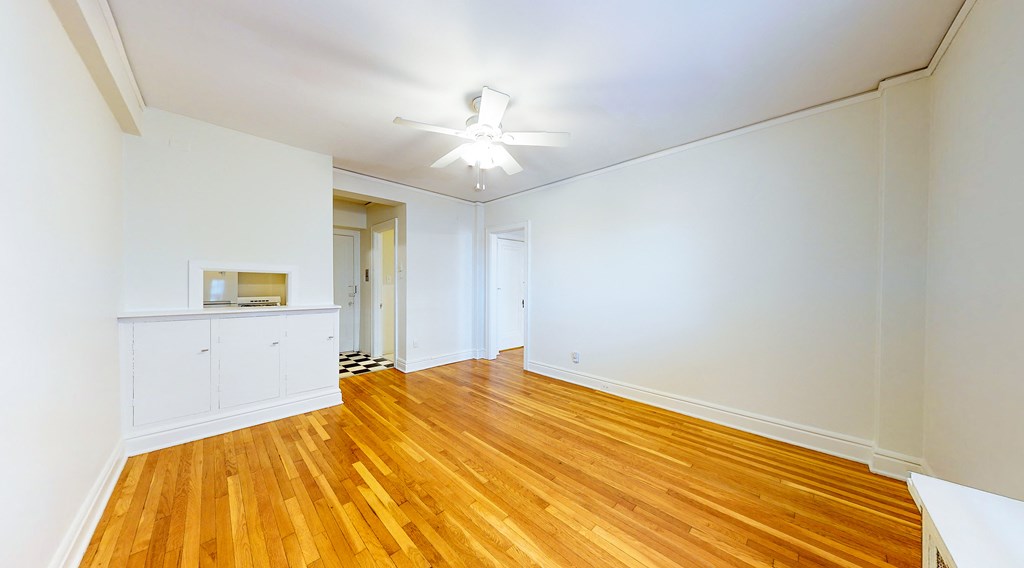 a living room with wood floors and a ceiling fan