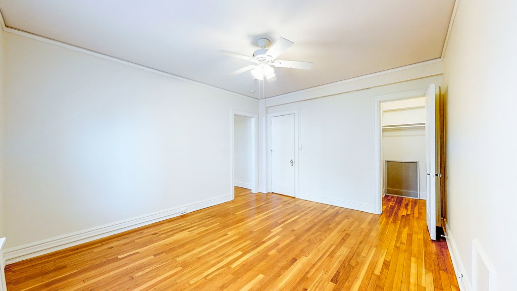 an empty room with wood floors and a ceiling fan