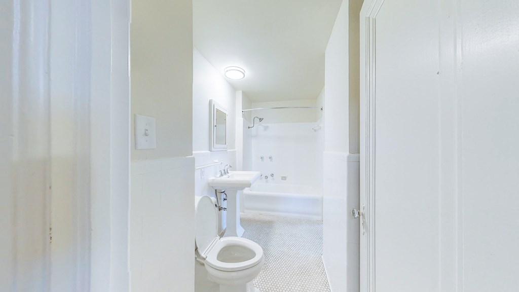 a white bathroom with a toilet and a sink