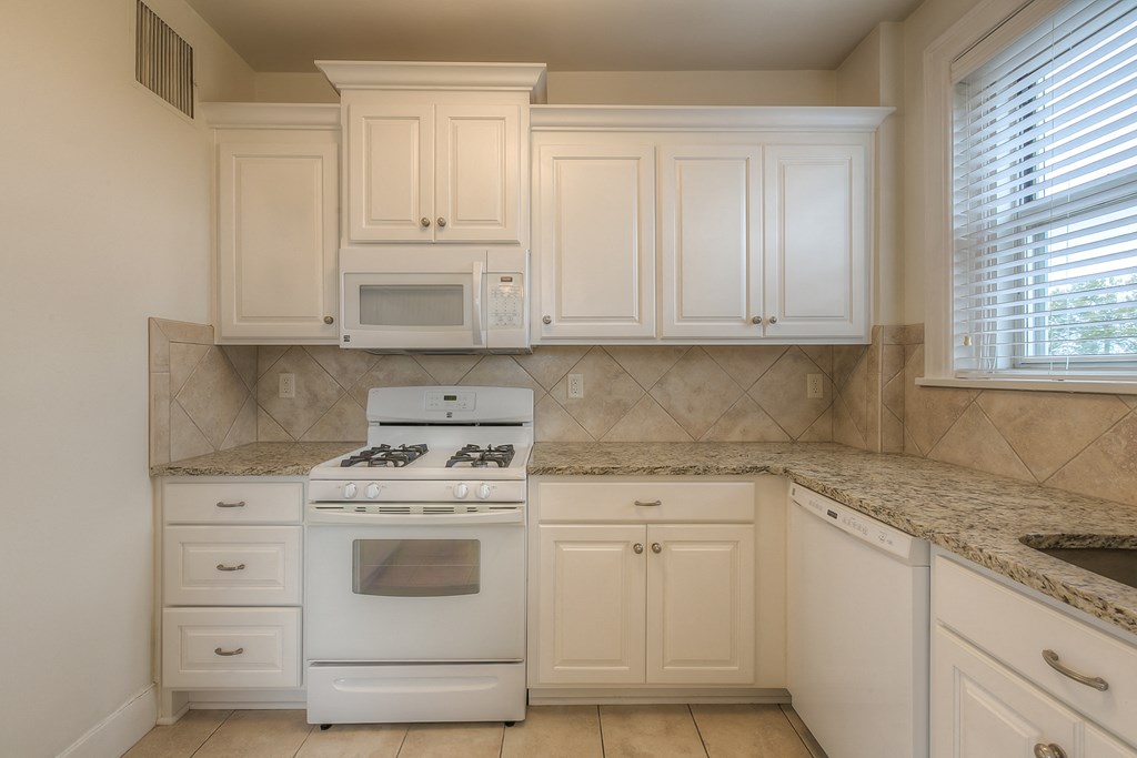 a kitchen with white appliances and white cabinets