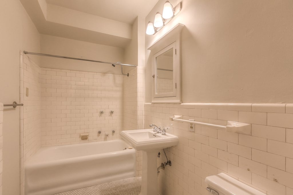a bathroom with a sink and a tub and a mirror