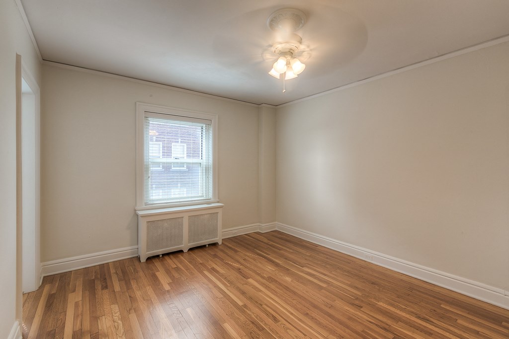 an empty living room with wood flooring and a window