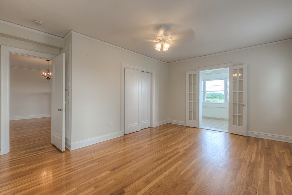 an empty living room with wood floors and white walls