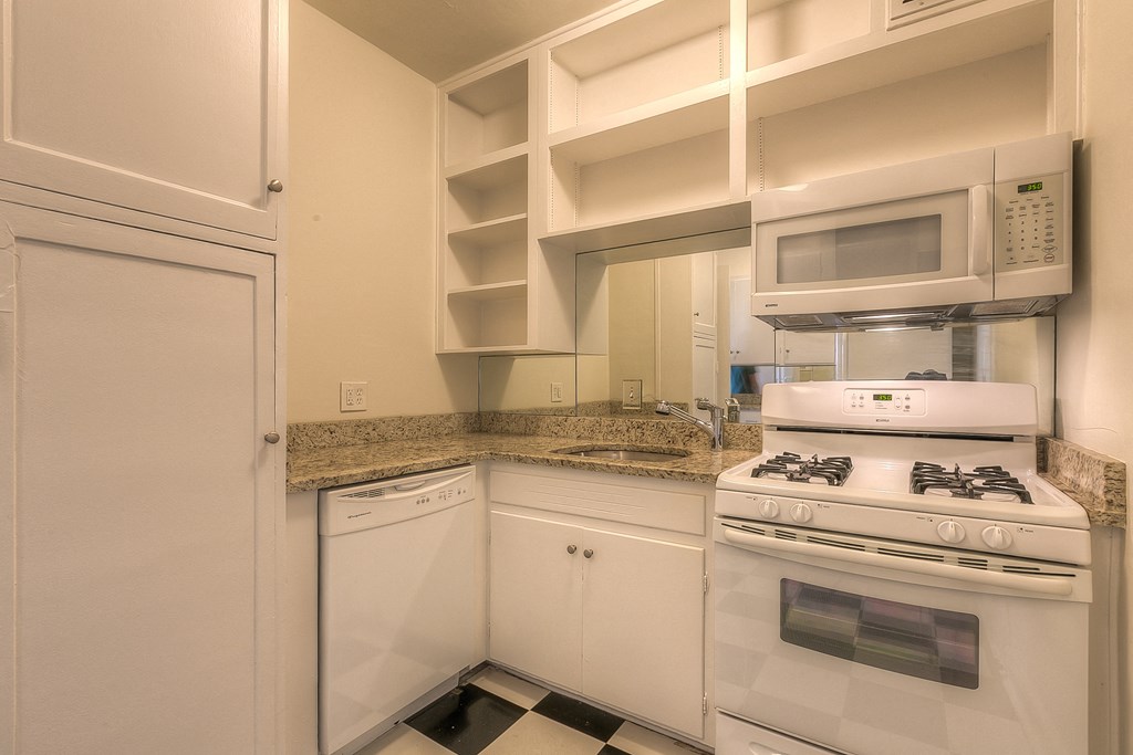 a kitchen with white appliances and granite counter tops