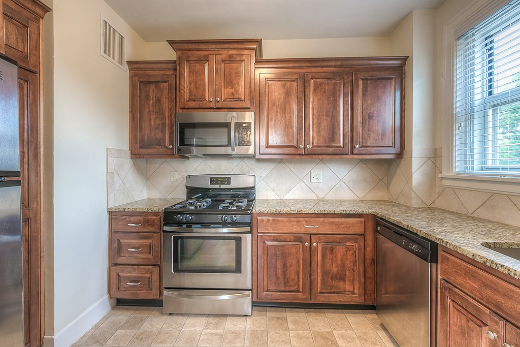 a kitchen with wooden cabinets and stainless steel appliances