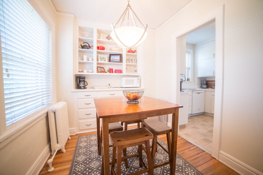 a dining room with a wooden table and two stools
