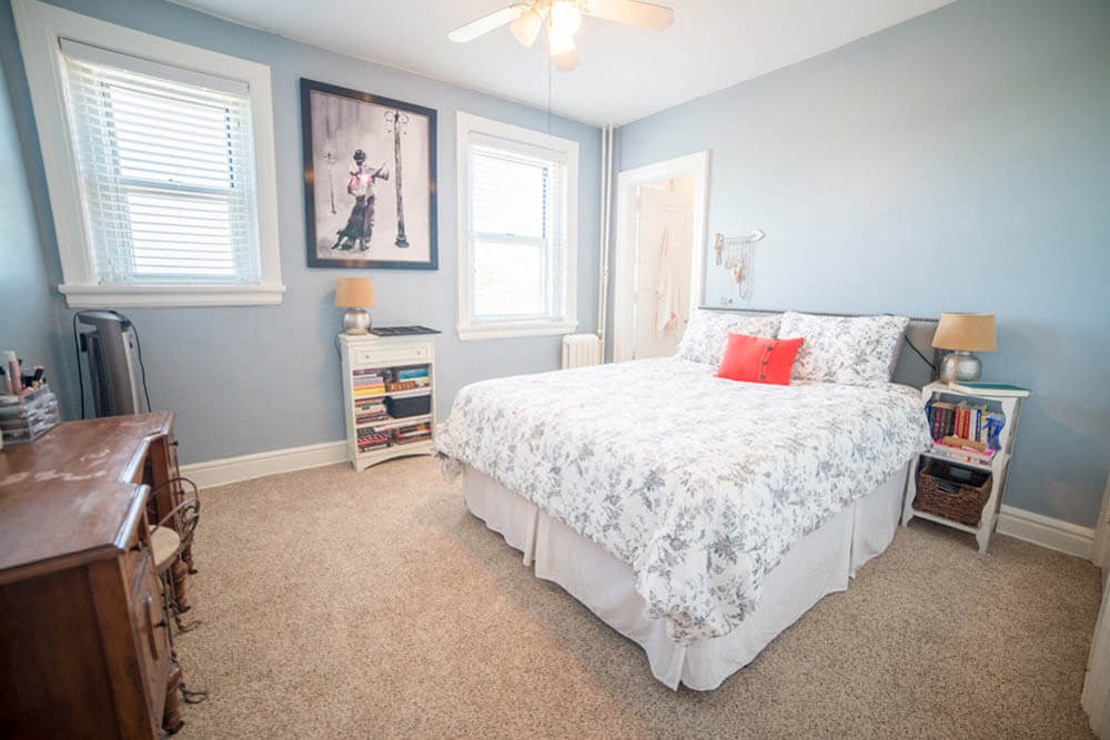 a bedroom with a bed and a dresser and a window