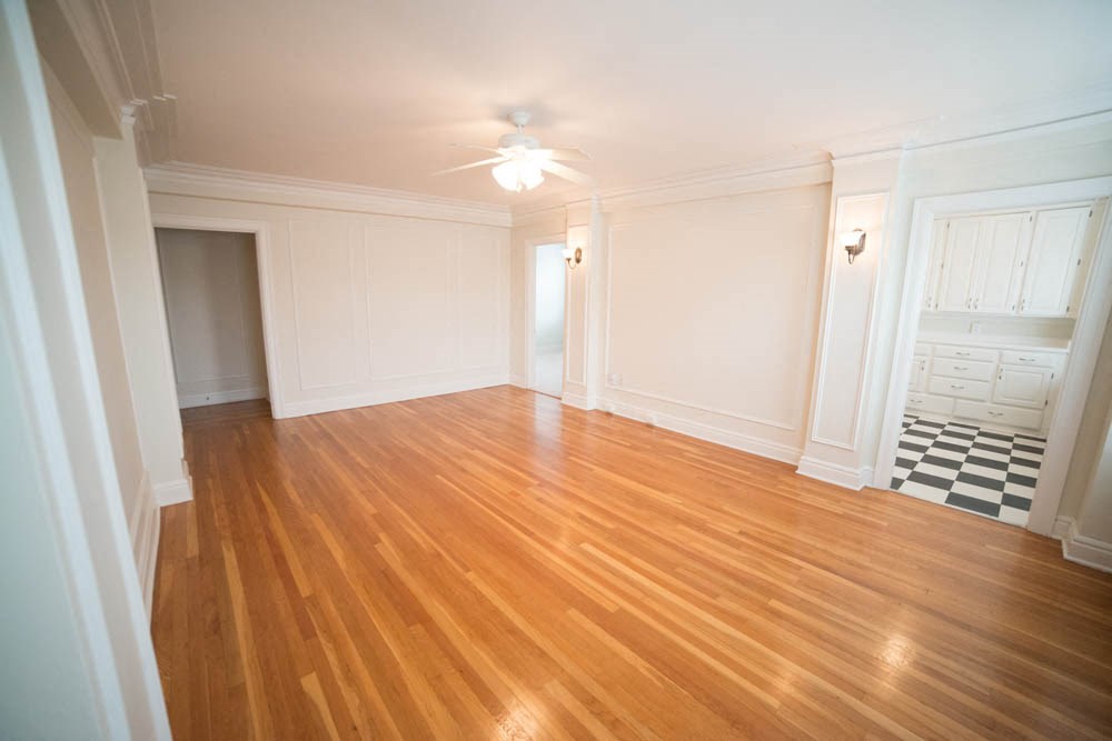an empty living room with a hard wood floor