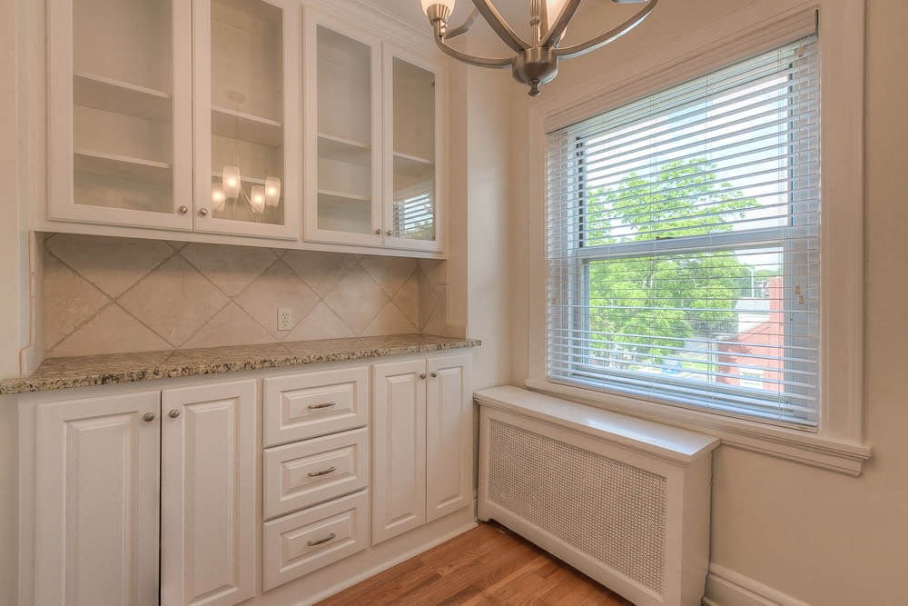 a white kitchen with white cabinets and a window