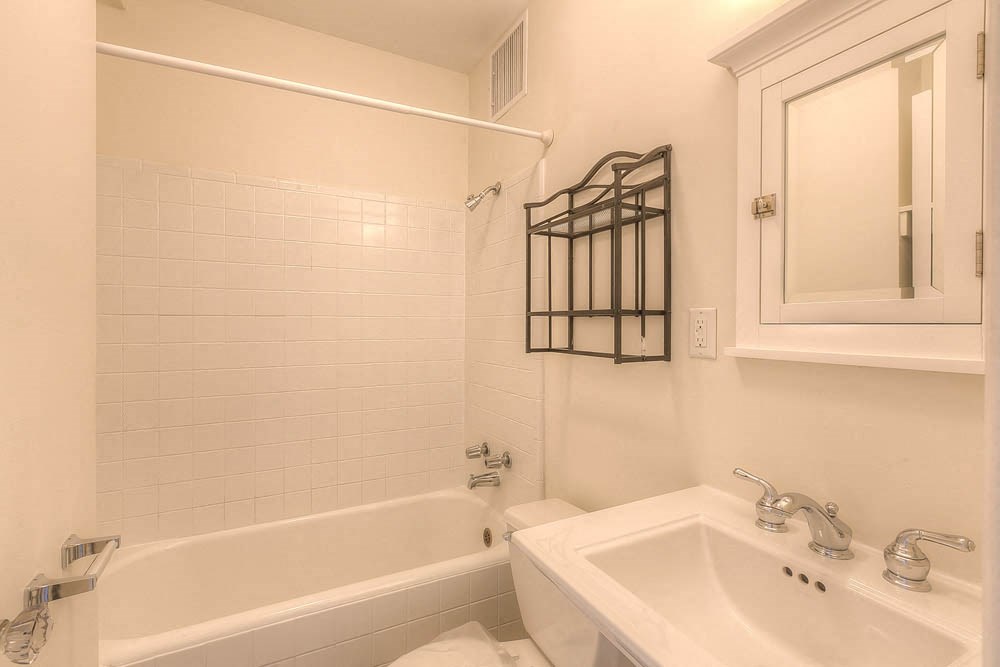 a white bathroom with a sink and a tub