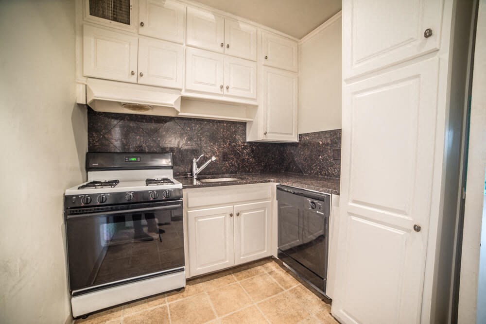 a kitchen with white cabinets and stainless steel appliances