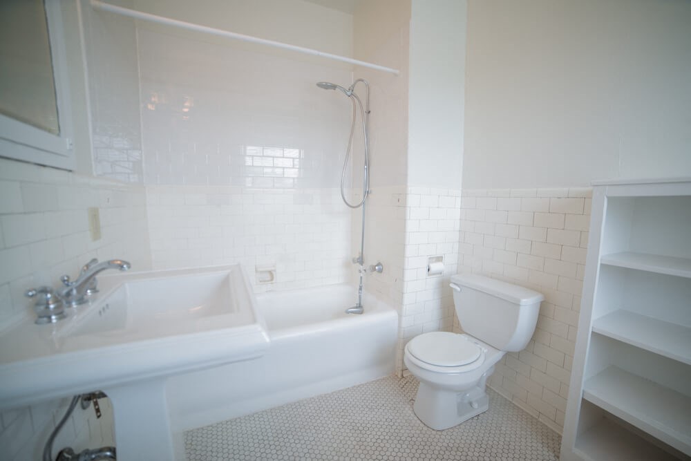 a white bathroom with a toilet and a sink