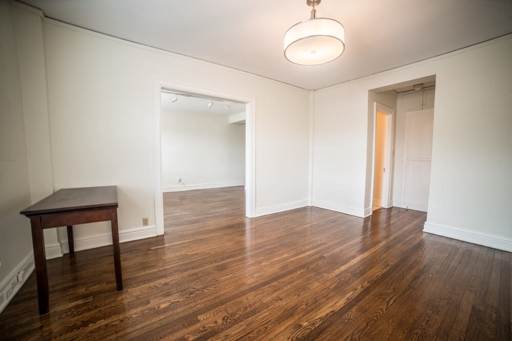 a empty living room with wood floors and a table