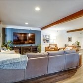 A grey couch with a white throw blanket on it.