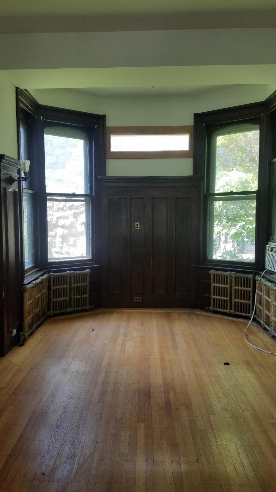 an empty room with wooden floors and windows