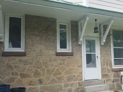 a stone house with a white door and windows