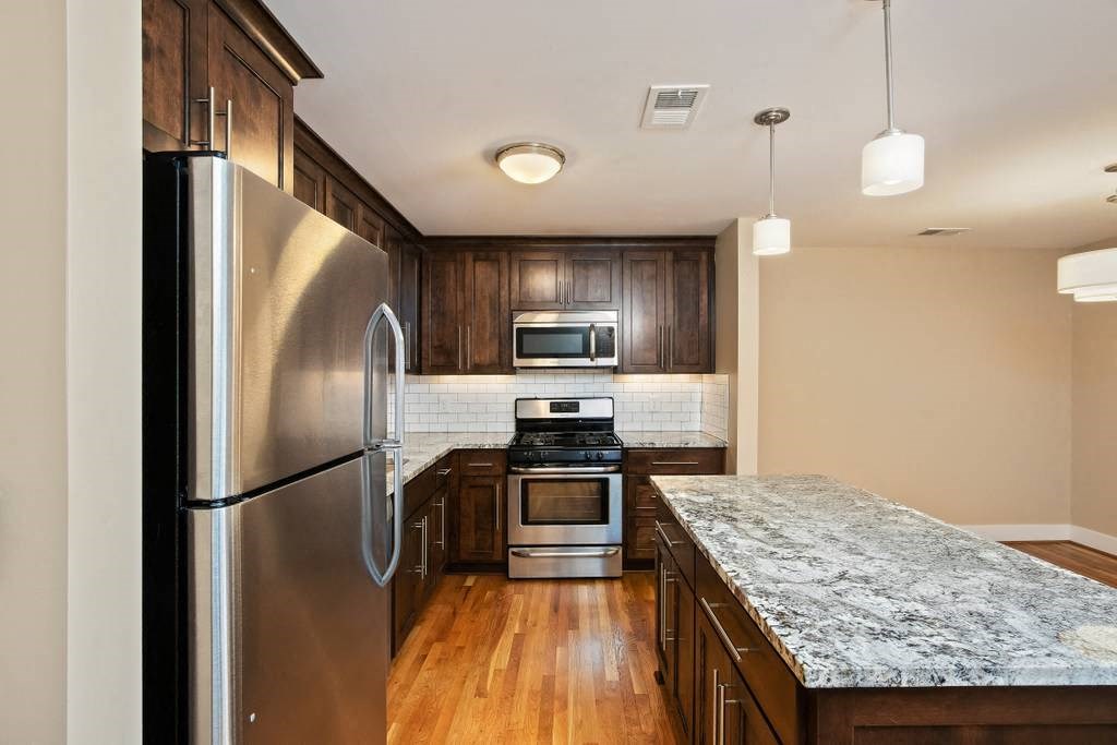 a kitchen with stainless steel appliances and marble counter tops