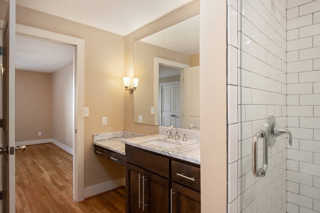a bathroom with a sink and a shower and a mirror