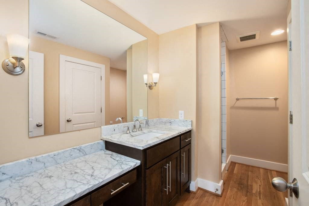 a bathroom with marble counter tops and a sink and a mirror