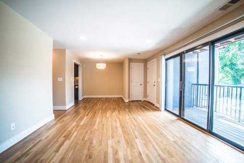 an empty living room with sliding glass doors to a balcony