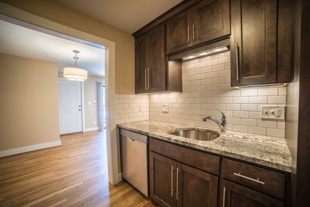 an empty kitchen with wooden cabinets and a sink