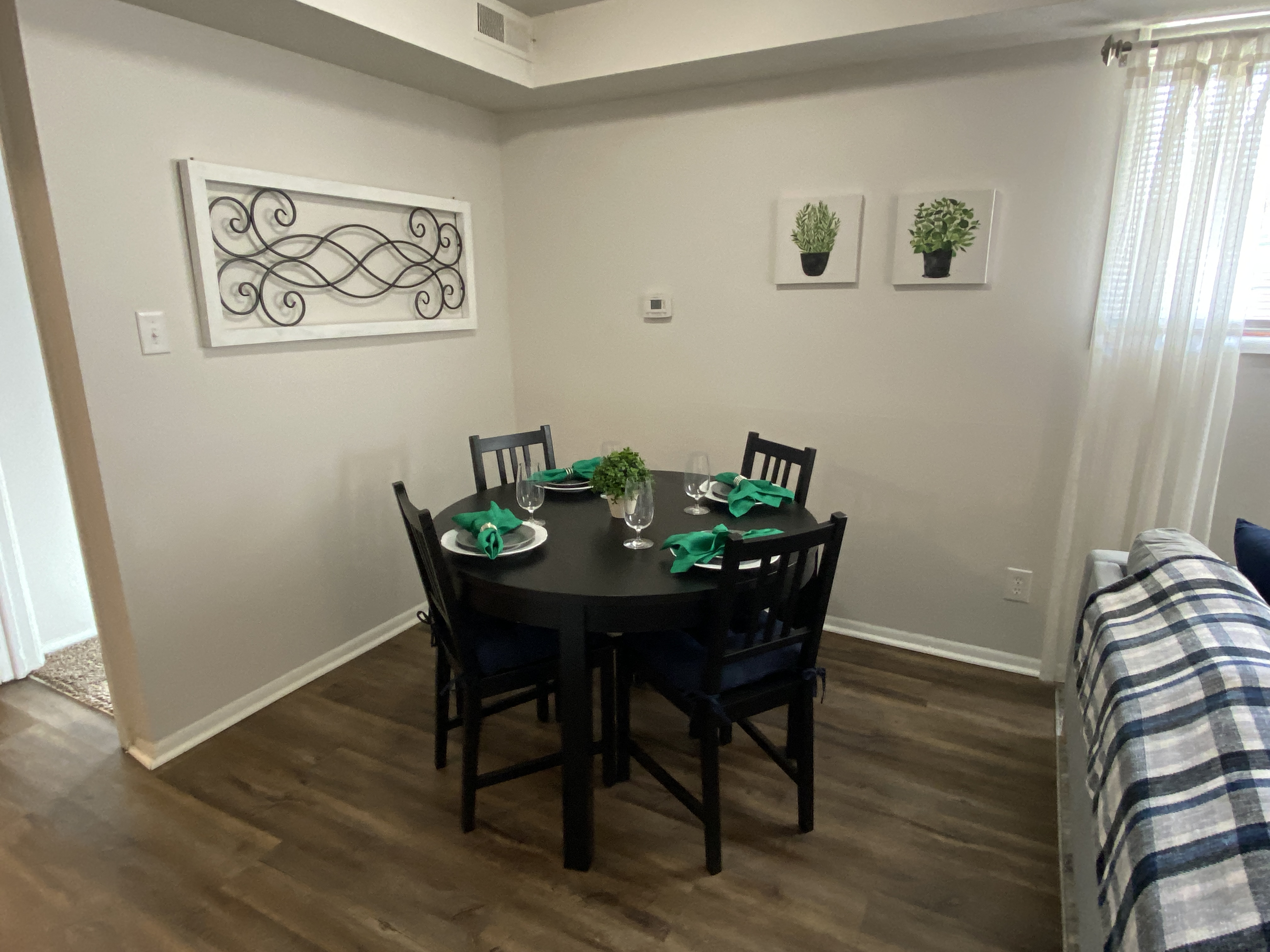 A dining room with a table set for four.