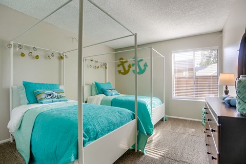 A bedroom with two beds and a dresser.