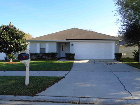 A house with a brown roof and a white garage door.