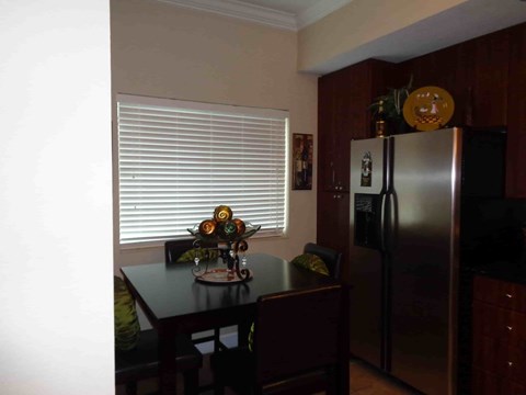 A kitchen with a table and chairs and a refrigerator.