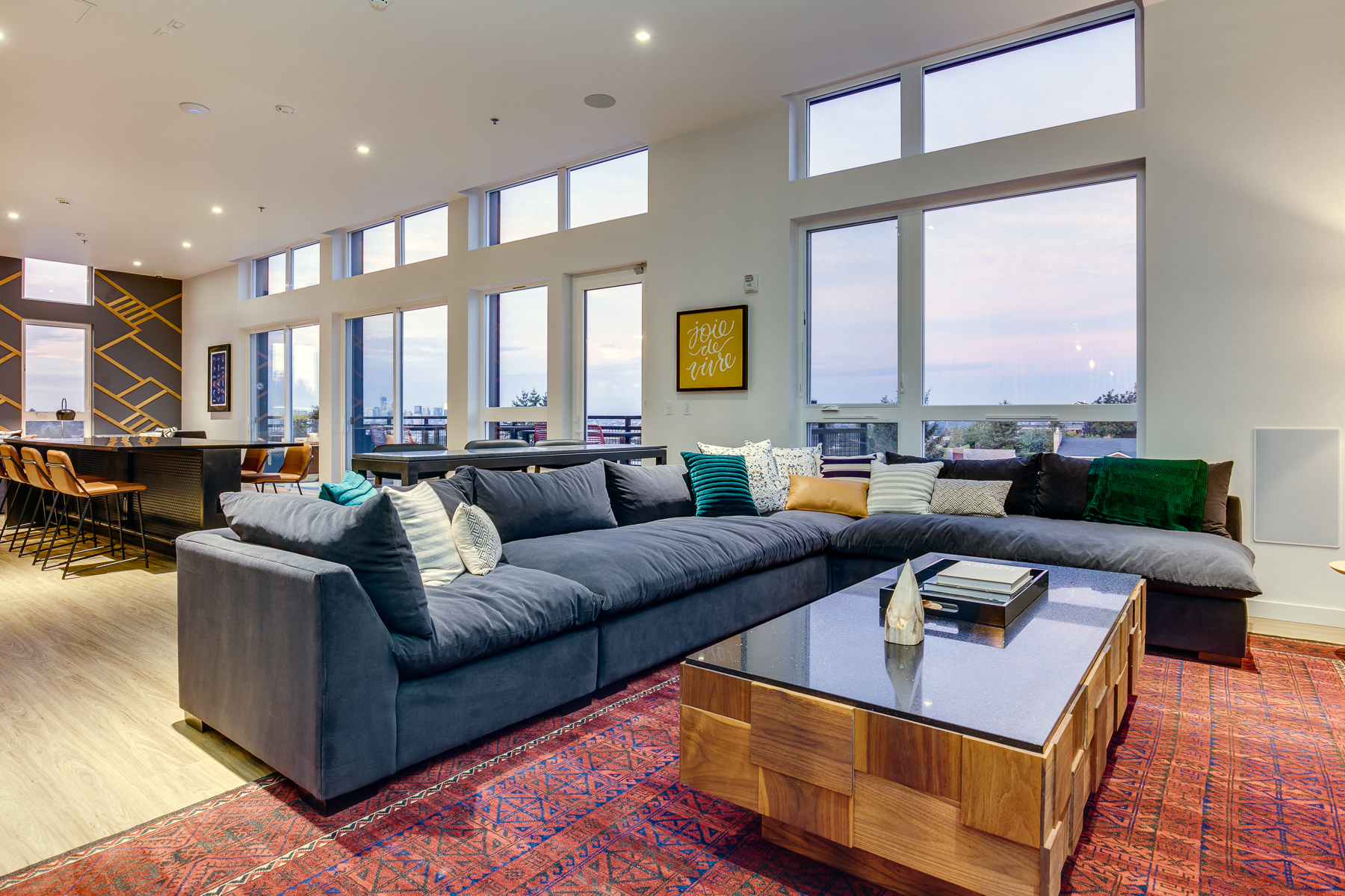 a large living room with large windows and a blue couch